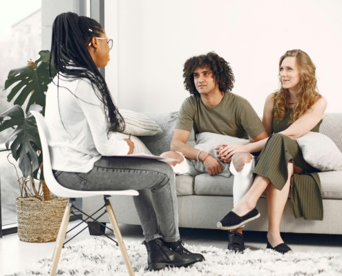 two people sitting on a couch with a therapist sitting across from them