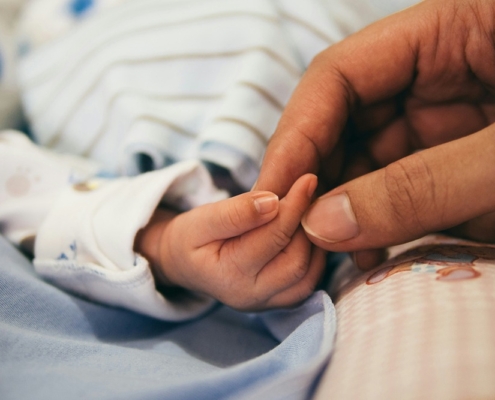 a newborn baby's hand being held by mothers hand