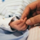 a newborn baby's hand being held by mothers hand